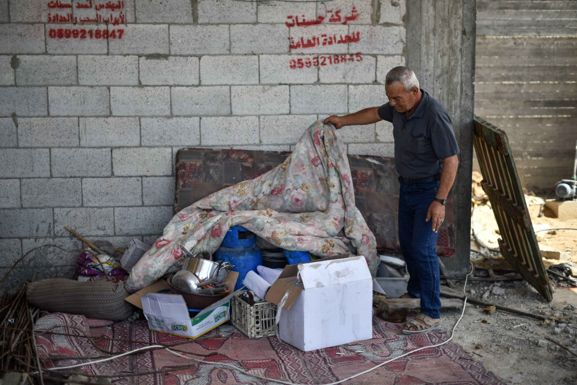 Abdel Fattah Shamallakh checking his personal belongings in his destroyed house, which is still under reconstruction.