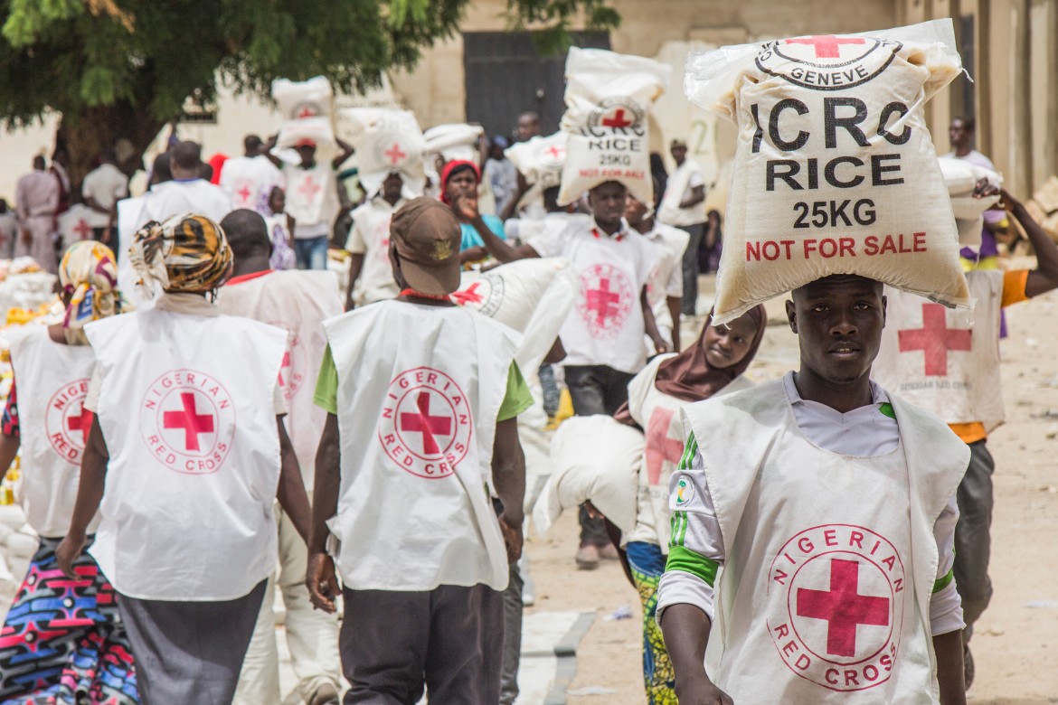 Volunteers of the Nigerian Red Cross and the ICRC distribute food items to internally displaced families in Maiduguri, Borno State.