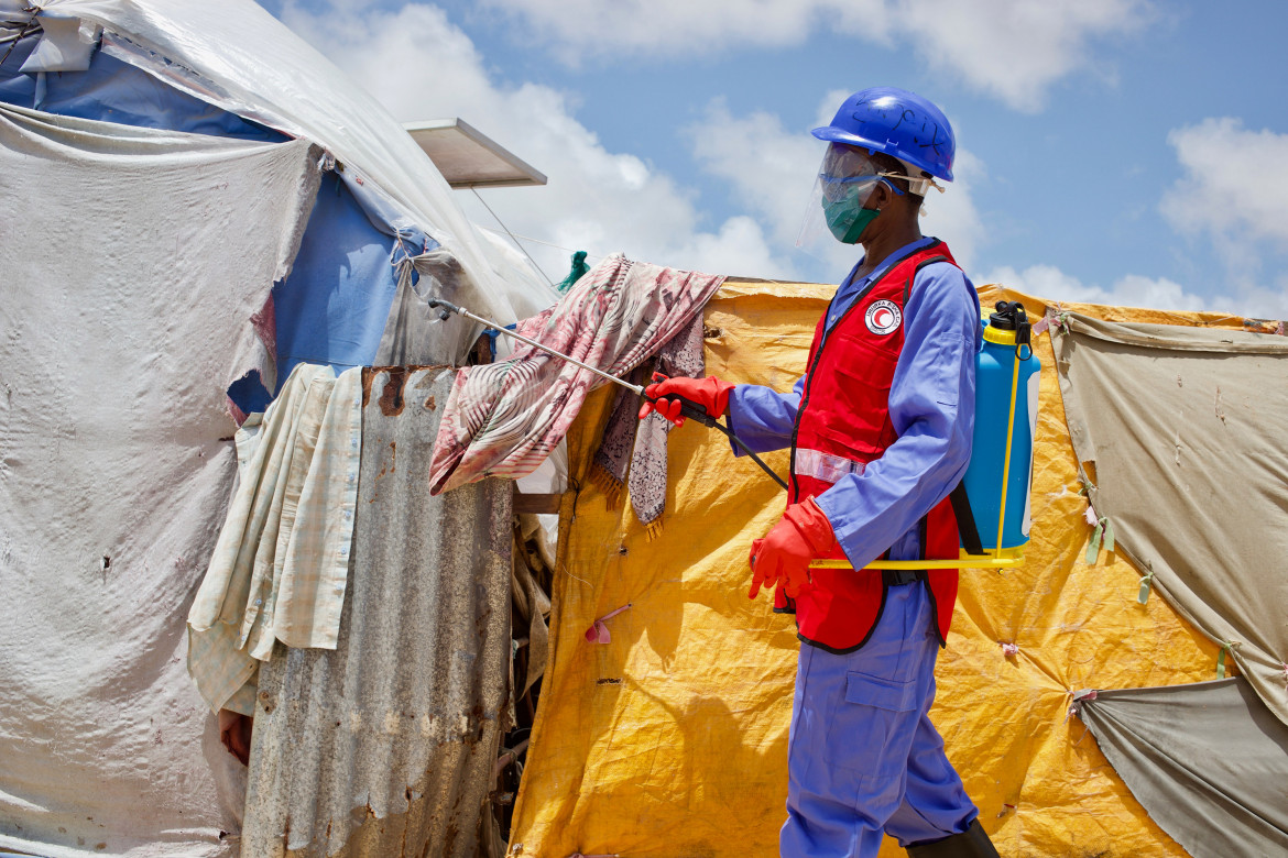 الصومال - يطهر موظفو الهلال الأحمر الصومالي الخيام في مخيم كابوي للنازحين داخليًا في مقديشو حيث يمكن أن يتفشي كوفيد-19 على نطاق واسع.