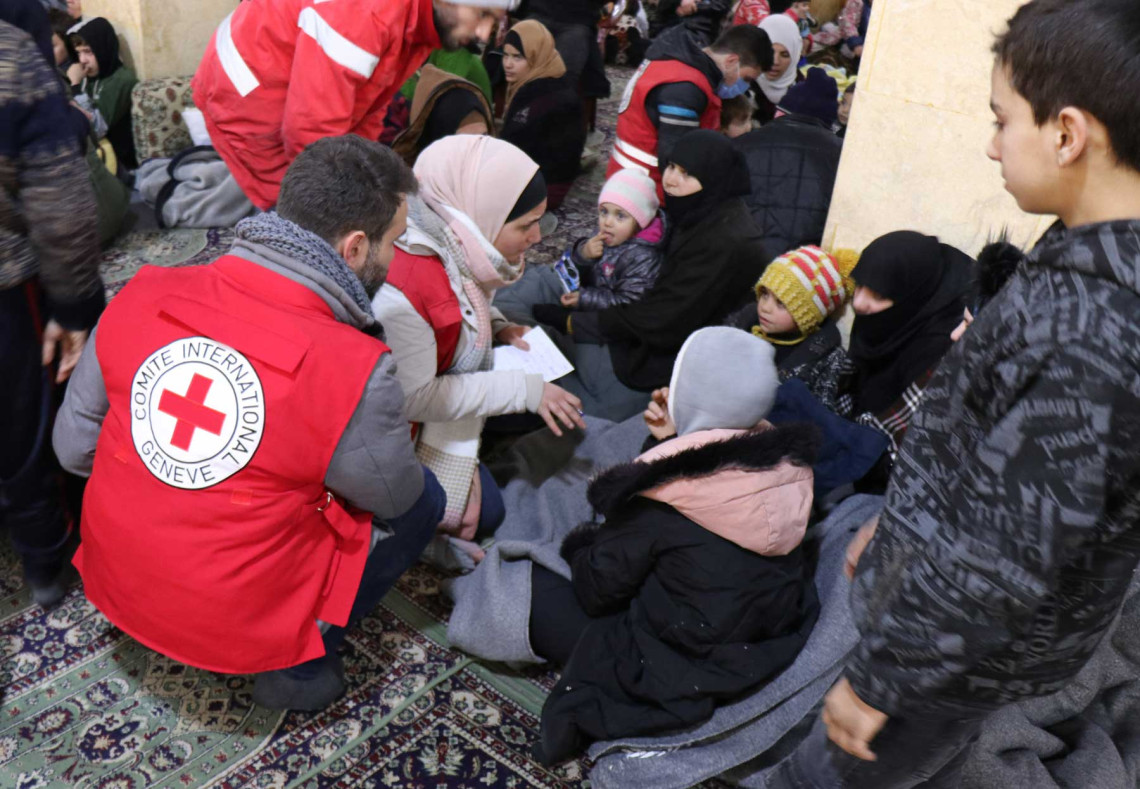 Un miembro del euqipo del CICR habla con familias afectadas por el terremoto en un refugio en Alepo. CICR/Kakhaber Khasaia