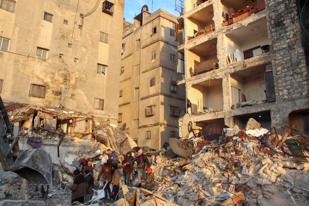 Des personnes se rassemblent dans les décombres alors que la recherche de survivants se poursuit, à la suite du tremblement de terre, à Alep, en Syrie, le 7 février 2023. REUTERS/Firas Makdesi