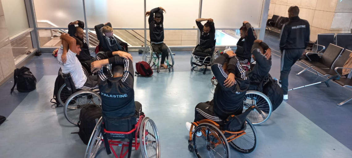 The team from the Gaza Strip keeps their focus and does stretching exercises while waiting at an airport en route to India’s first international wheelchair basketball tournament. 