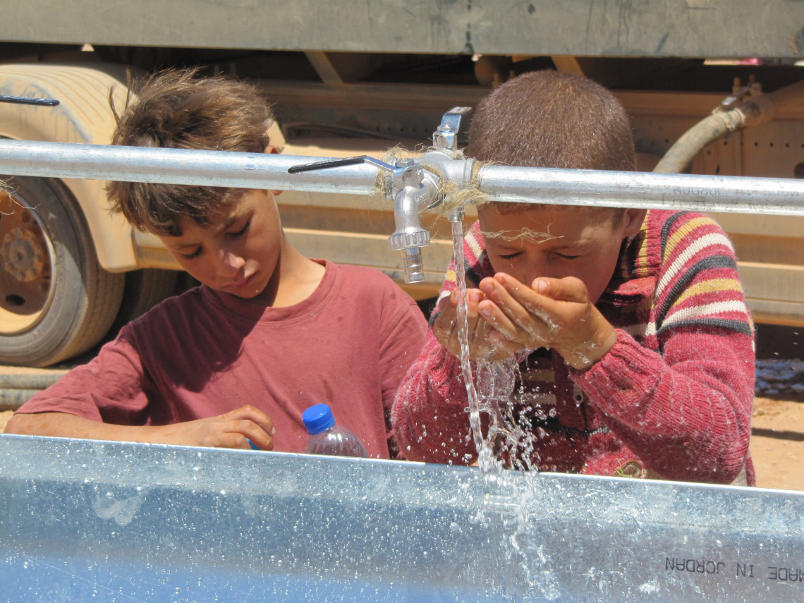 North-East Jordan, close to the Syrian border, Bustana, Syrian kids enjoying clean water after the ICRC installed washing basins at several posts along the border /ICRC 