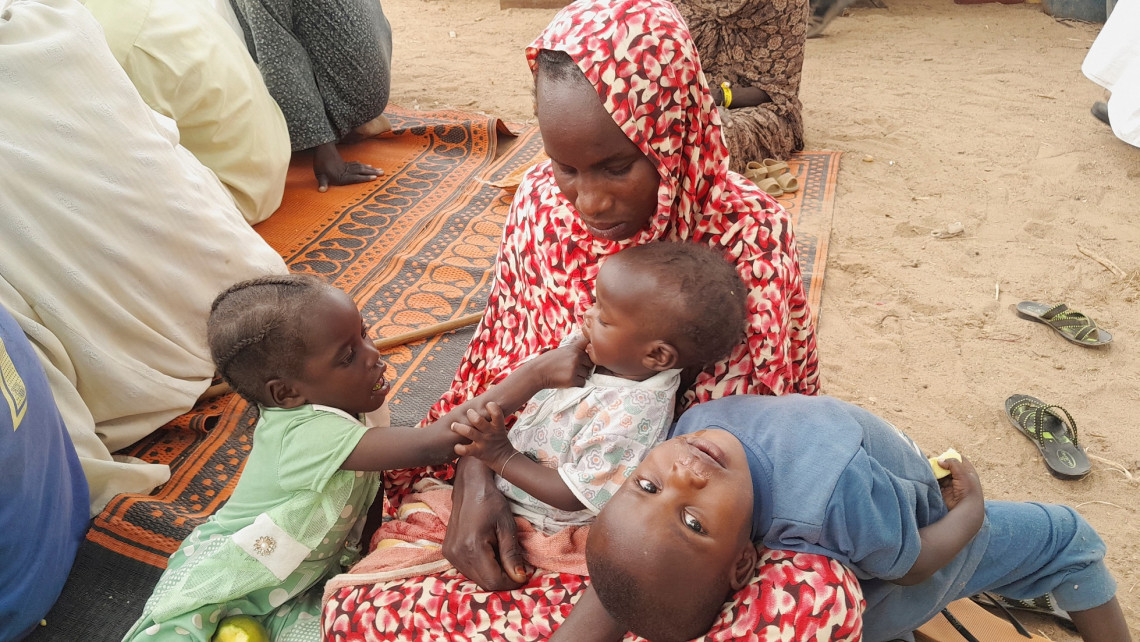 A Sudanese refugee who fled the violence in her country is seen with her children as she gathers with other refugees near the border between Sudan and Chad, in Koufroun, Chad April 29, 2023. REUTERS/Mahamat Ramadane