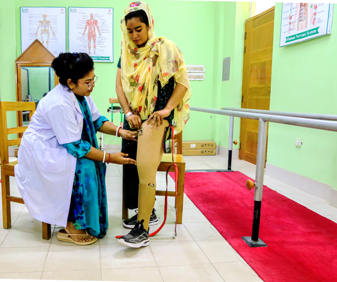 Anita Rani Sarker helping her patient Shakila stand on both her legs at an ICRC-supported Physical Rehabilitation Centre in Savar in Dhaka, Bangladesh.