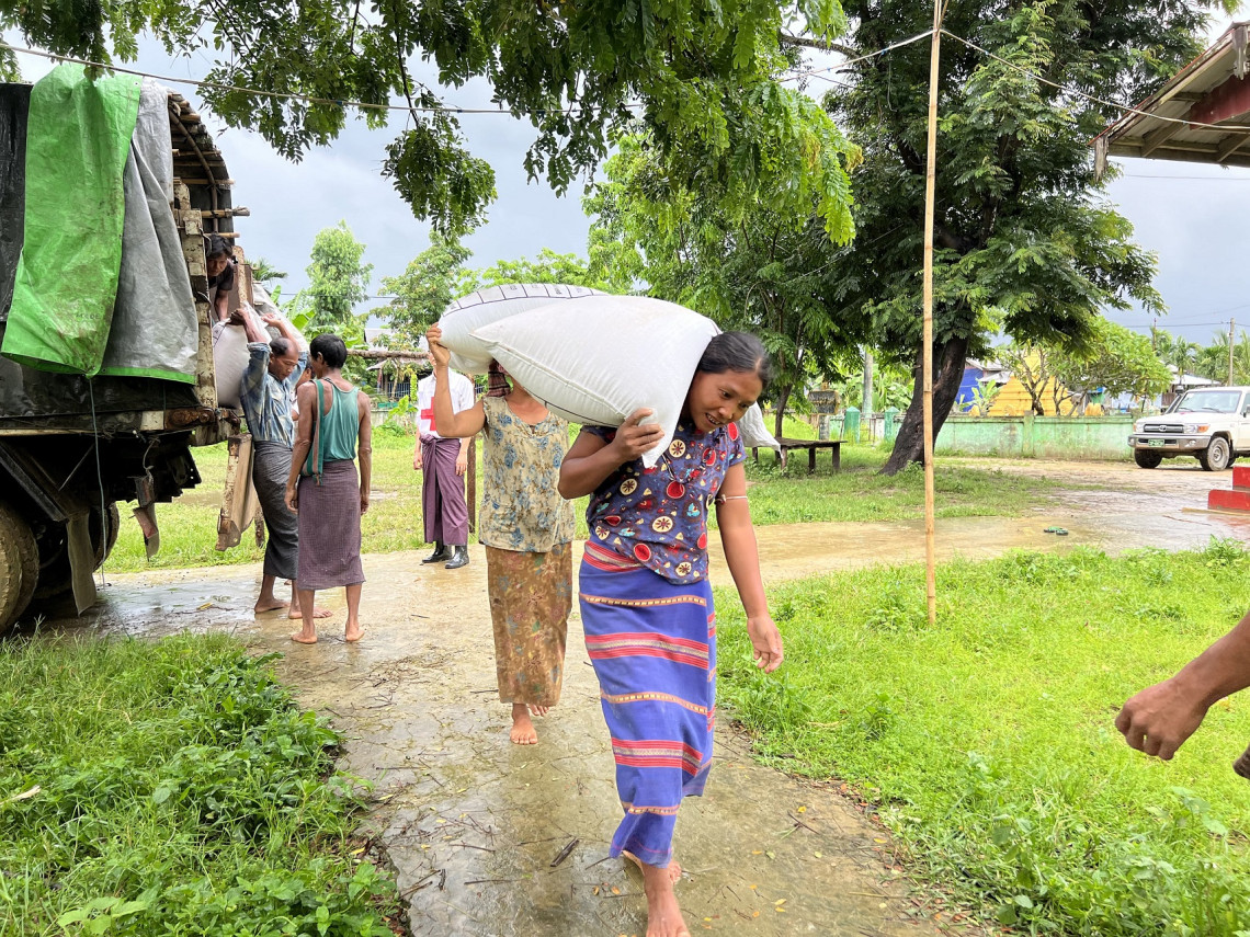 社区成员将一袋袋水稻种子搬运到若开邦的一个派发点。
