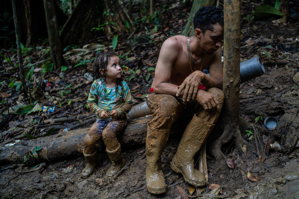 O imigrante venezuelano Luis Miguel Arias (28) e sua filha Melissa (4) fazem uma pausa enquanto sobem um morro no Tampão de Darién, entre a Colômbia e o Panamá. Ele cruzou o Tampão com a esposa, seus dois filhos e um amigo. 