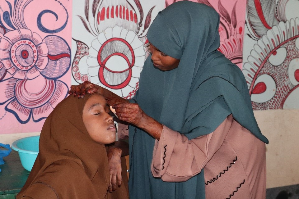 Fauzia Dekow applying make up to one of her clients