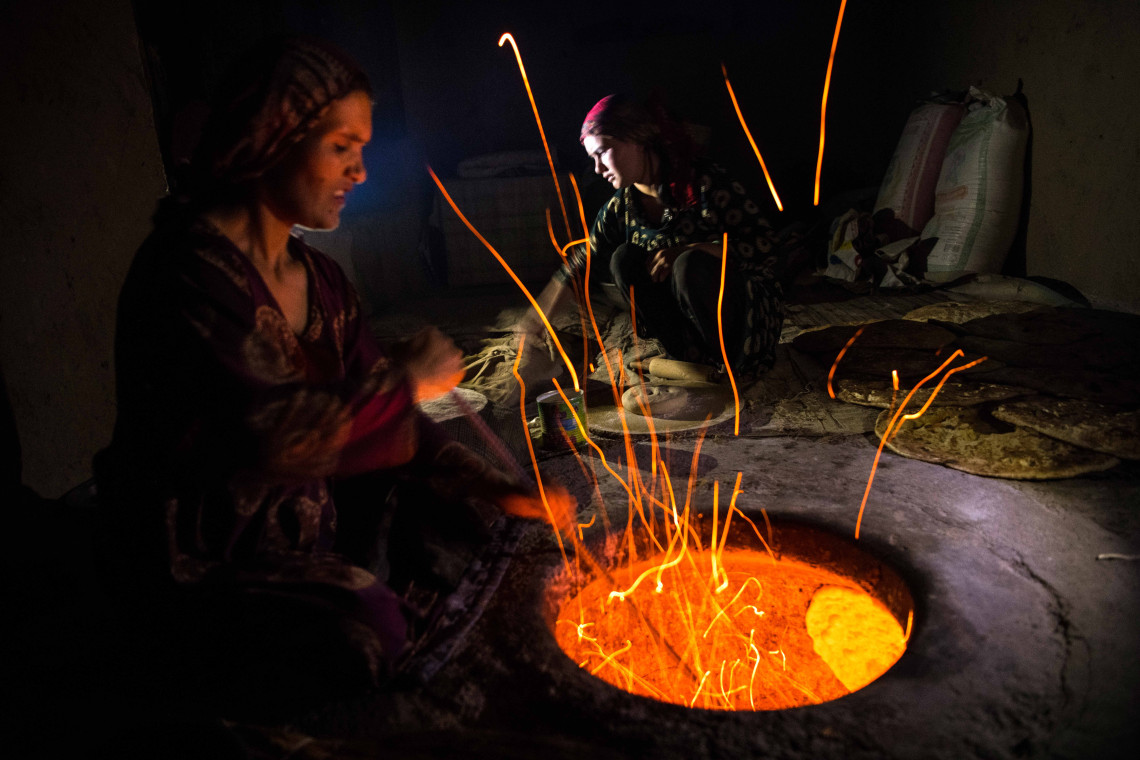 Faizabad, Afghanistan. Une femme fabrique du pain à l’aube. On estime qu’après des décennies de conflit armé, plus de la moitié de la population (24 millions de personnes) a besoin d’aide humanitaire et l’insécurité alimentaire aiguë touche près de 20 millions de personnes en Afghanistan (chiffres de 2022).