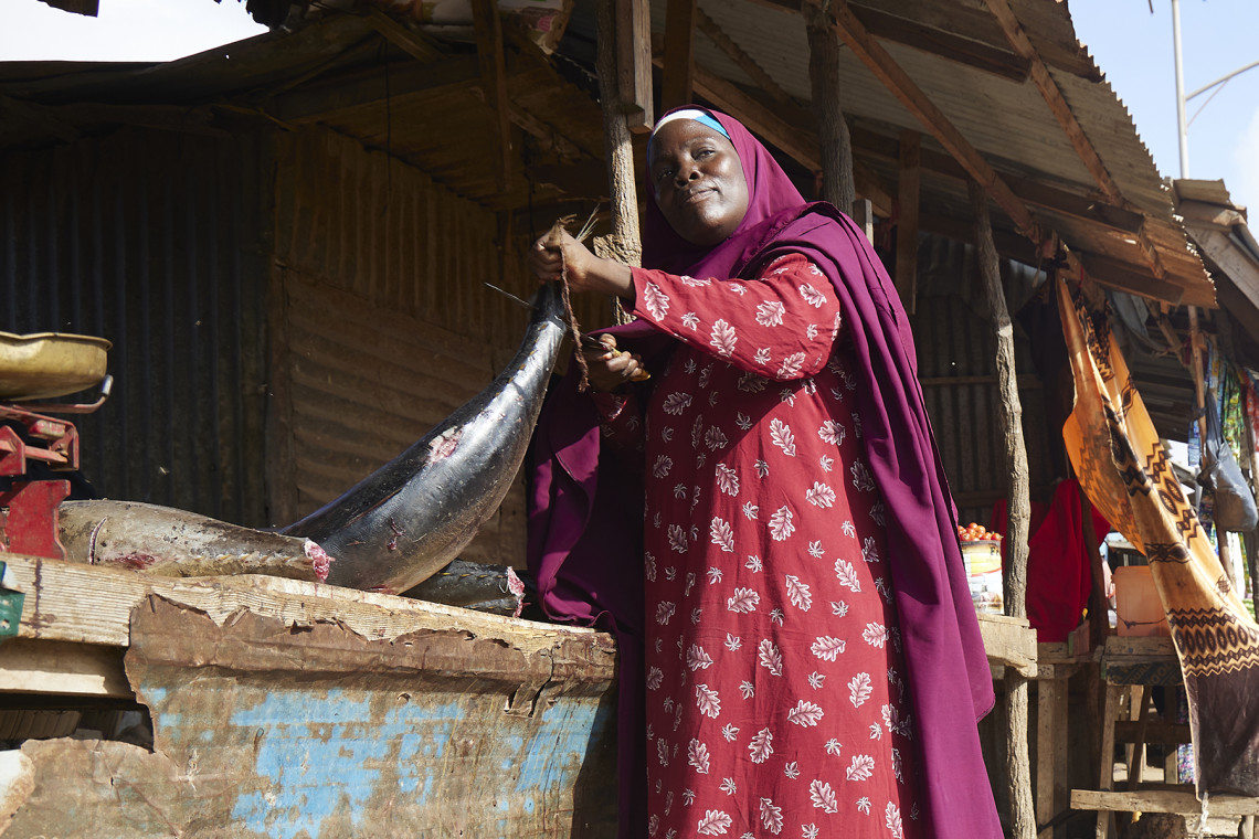 Algunas de las personas desplazadas que residen en el campamento Dalhiska, en Kismayo, venden pescado para mantener a sus familias. Su día comienza a la mañana temprano con un viaje a la playa y los mercados para comprar pescado fresco. Maryan Abdullahi limpia y prepara los pescados para venderlos en su puesto del campamento de Dalhishka. 