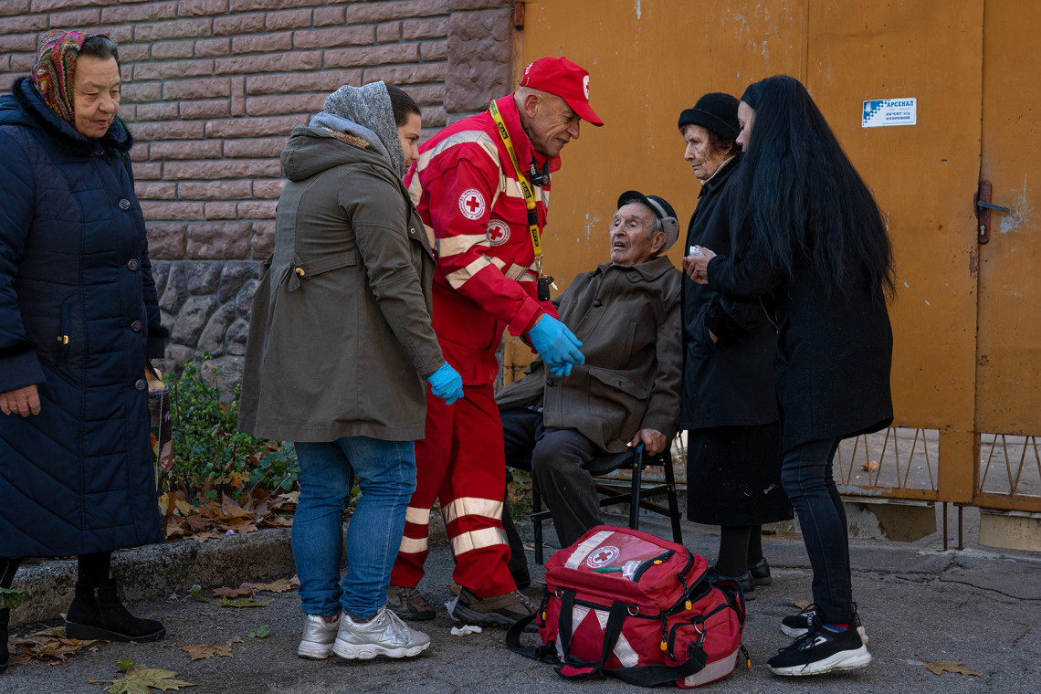 Um voluntário ucraniano da Cruz Vermelha presta primeiros socorros a um residente de Kherson.