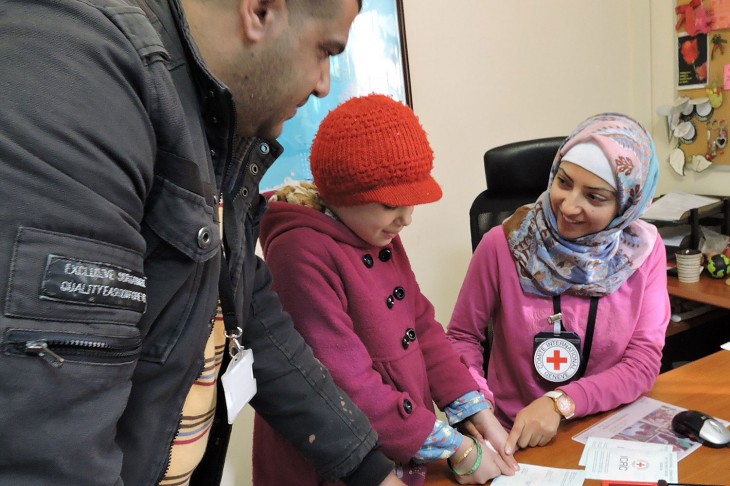 Refugiados sirios : Oficina del CICR, Amán, Jordania. Al igual que su hermano, la hija de Abu Umran da sus huellas digitales para confeccionar su documento de viaje. CC BY-NC-ND / CICR 